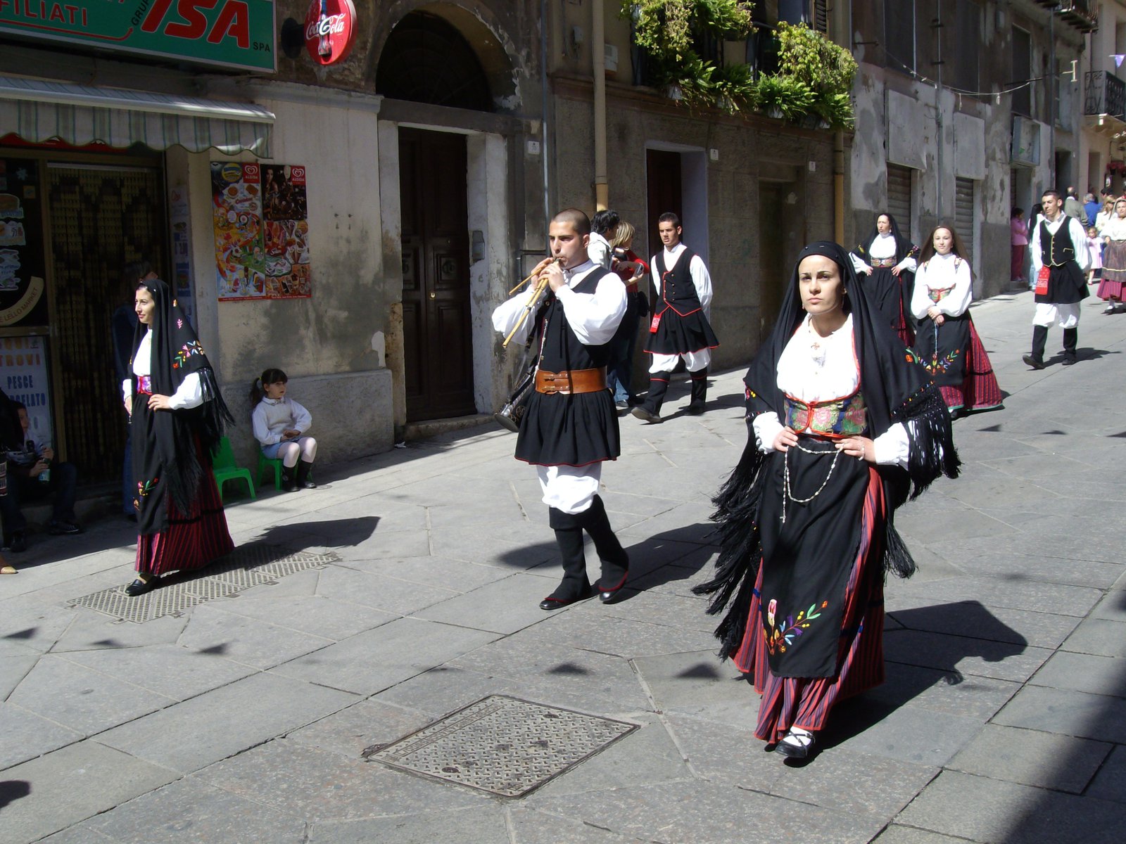 Traditional costumed procession and decorated traccas ox-carts of Festa di Sant'Efisio arriving at Nora